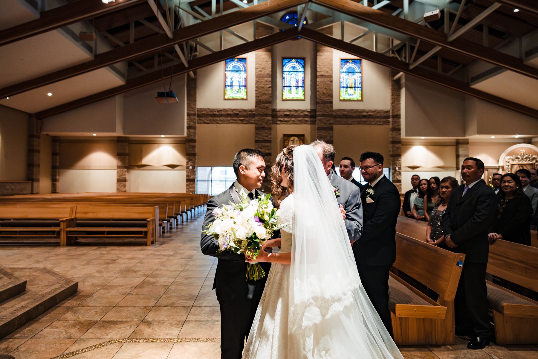 Bride and groom meeting at the altar during the Catholic wedding ceremony in Murrieta