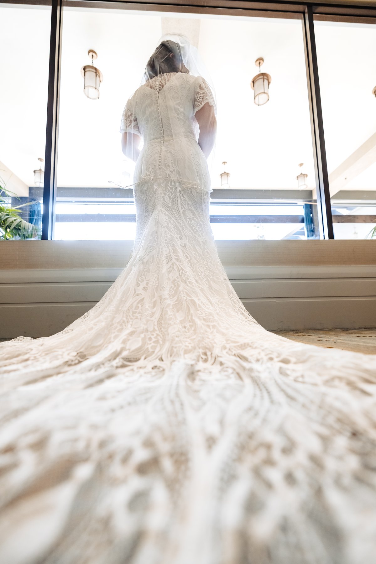Bridal portrait, lace train cascading toward the camera before the Nuptial Mass