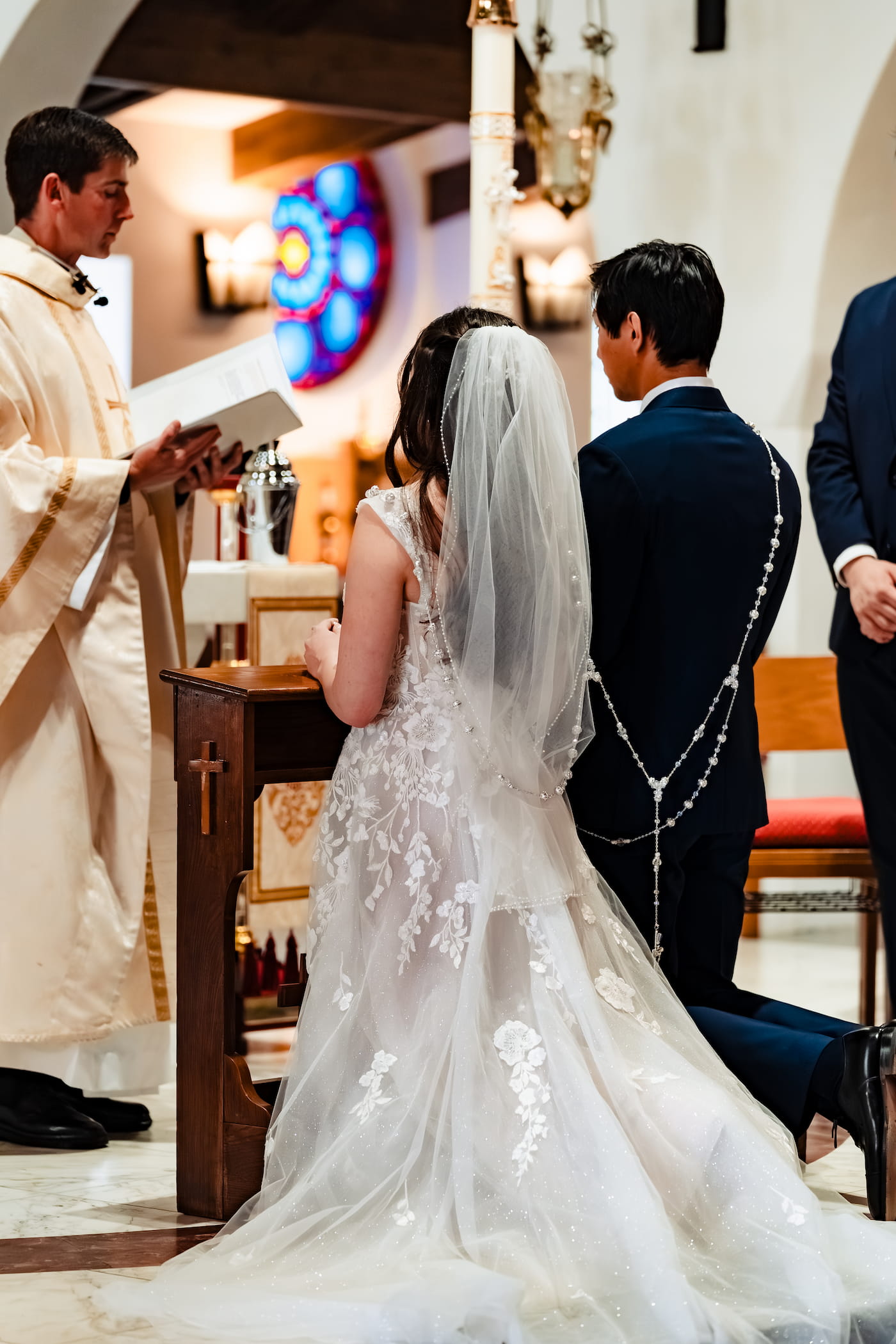 The couple kneeling during the wedding Mass
