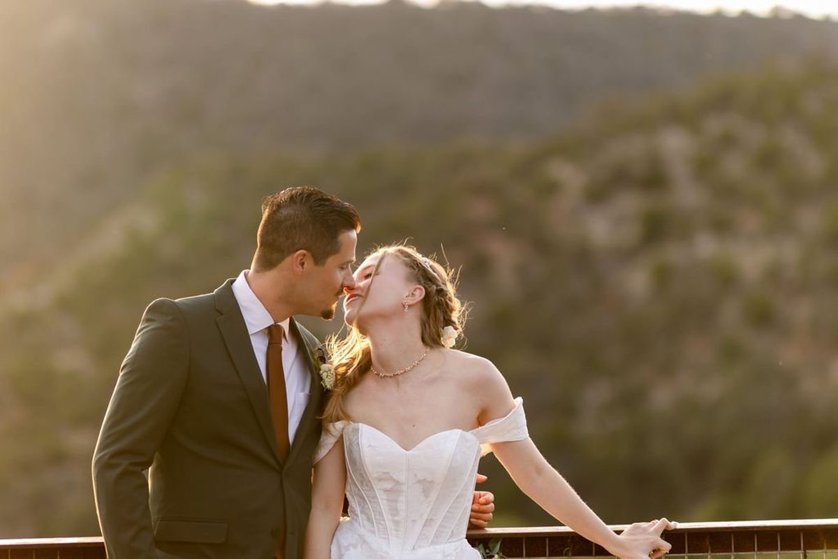 Francis and Aubrey kissing at sunset above Wooten Canyon at Aspen Falls Venue, New Mexico