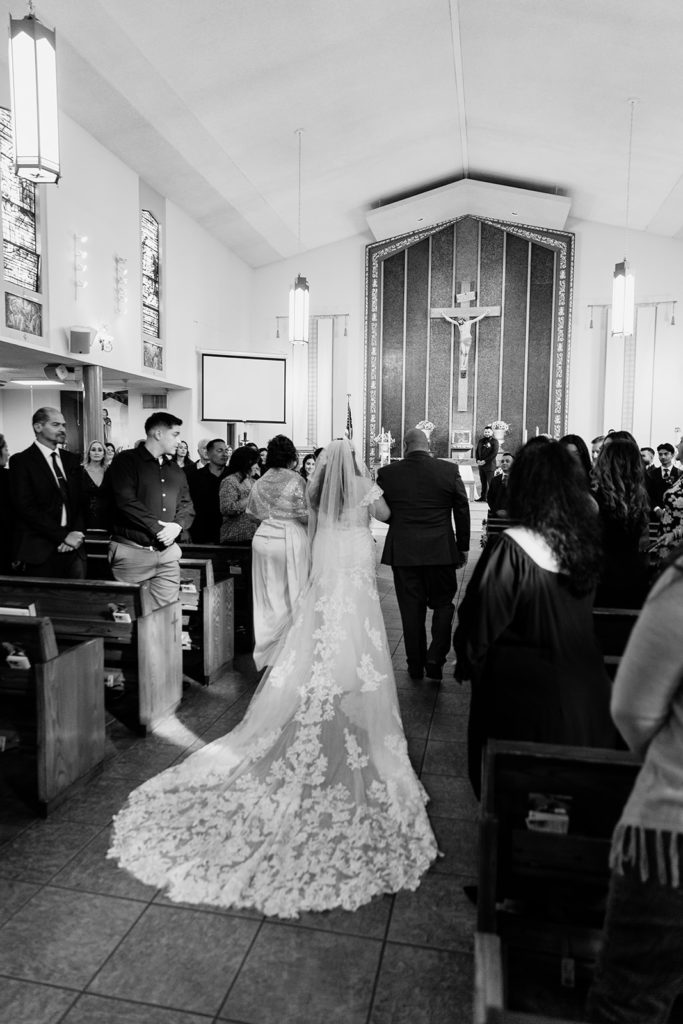 Bride walking down the isle with her parents at Holy Family Parish in Bellflower, California