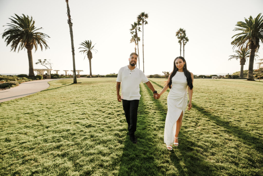 couple holding hands and walking during susnet at Laguna Beach