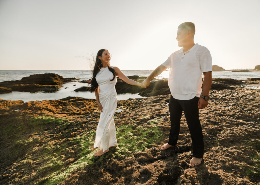 Couple walking on the Rocks at Laguna Beach Shore