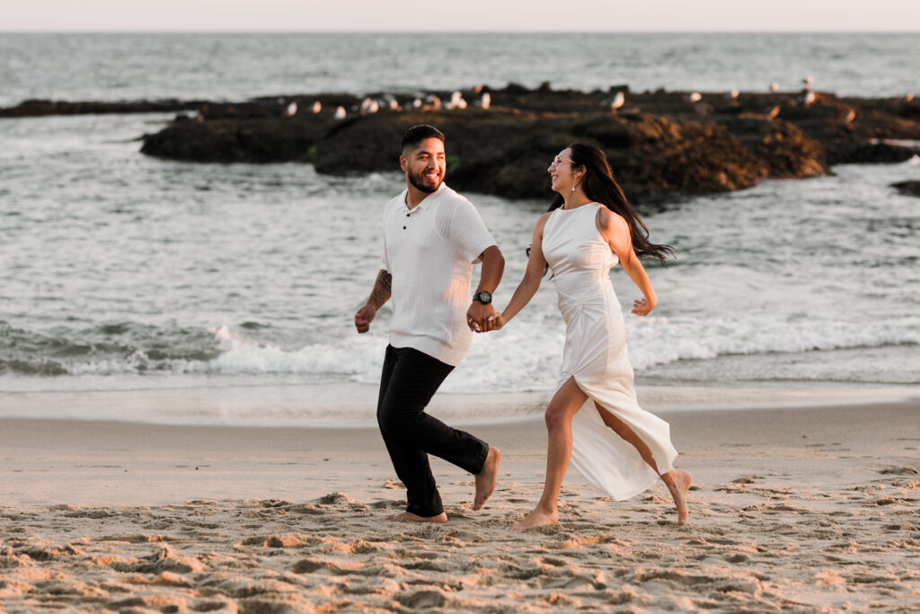 Couple running on shore during sunset on Laguna Beach