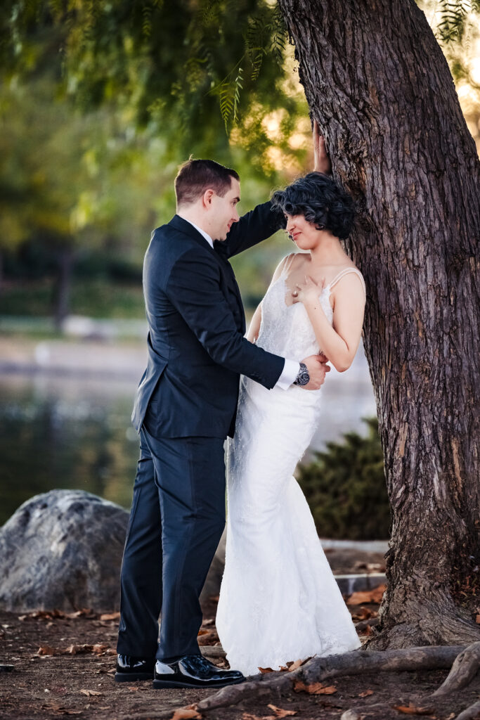 Bride and groom laughing together under tree after Mass wedding at Saint Martha’s