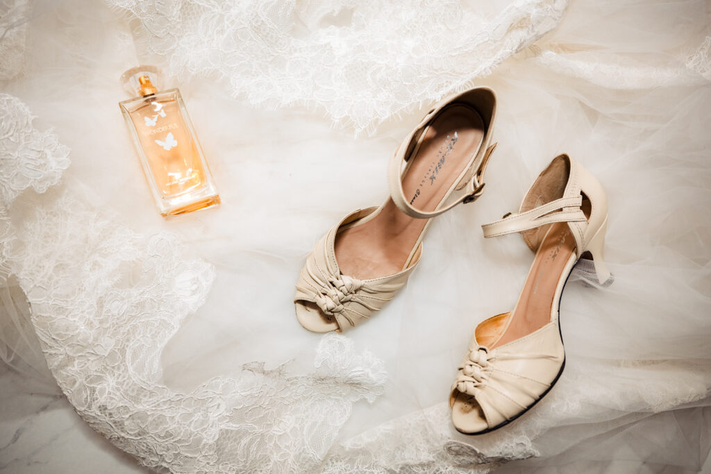 Flat lay of bride’s wedding shoes and veil with soft natural light in bridal suite