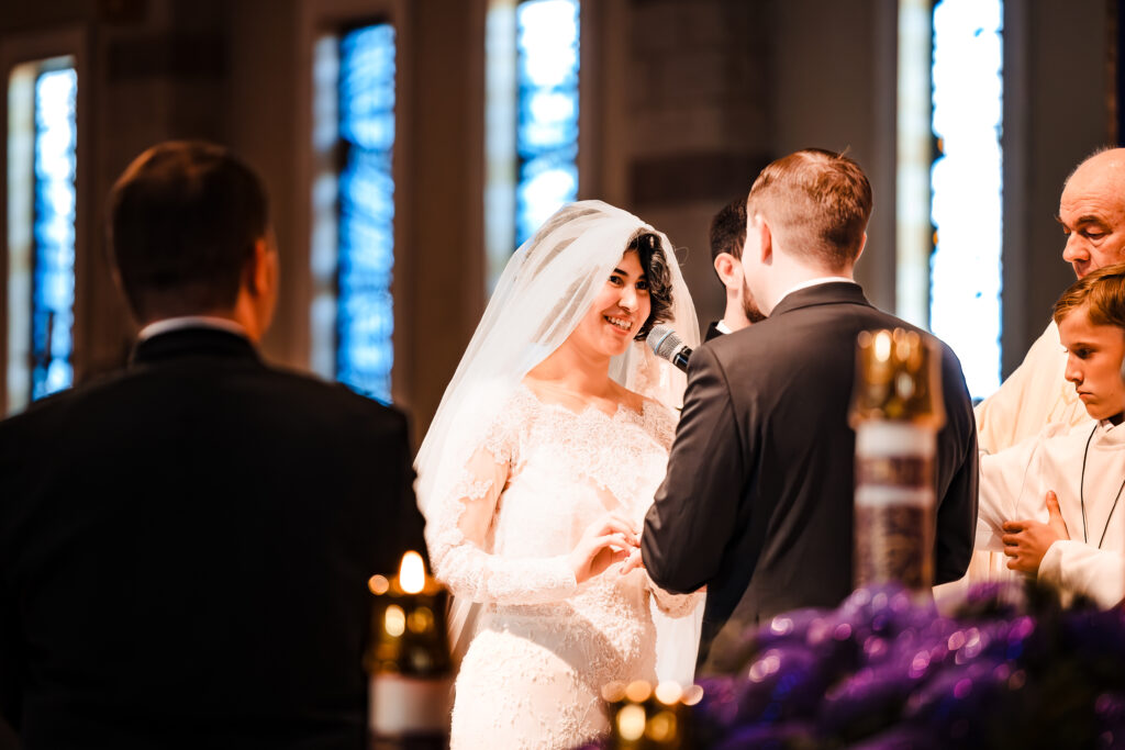 Bride and groom exchange vows at the altar during Catholic Mass wedding at Saint Martha’s
