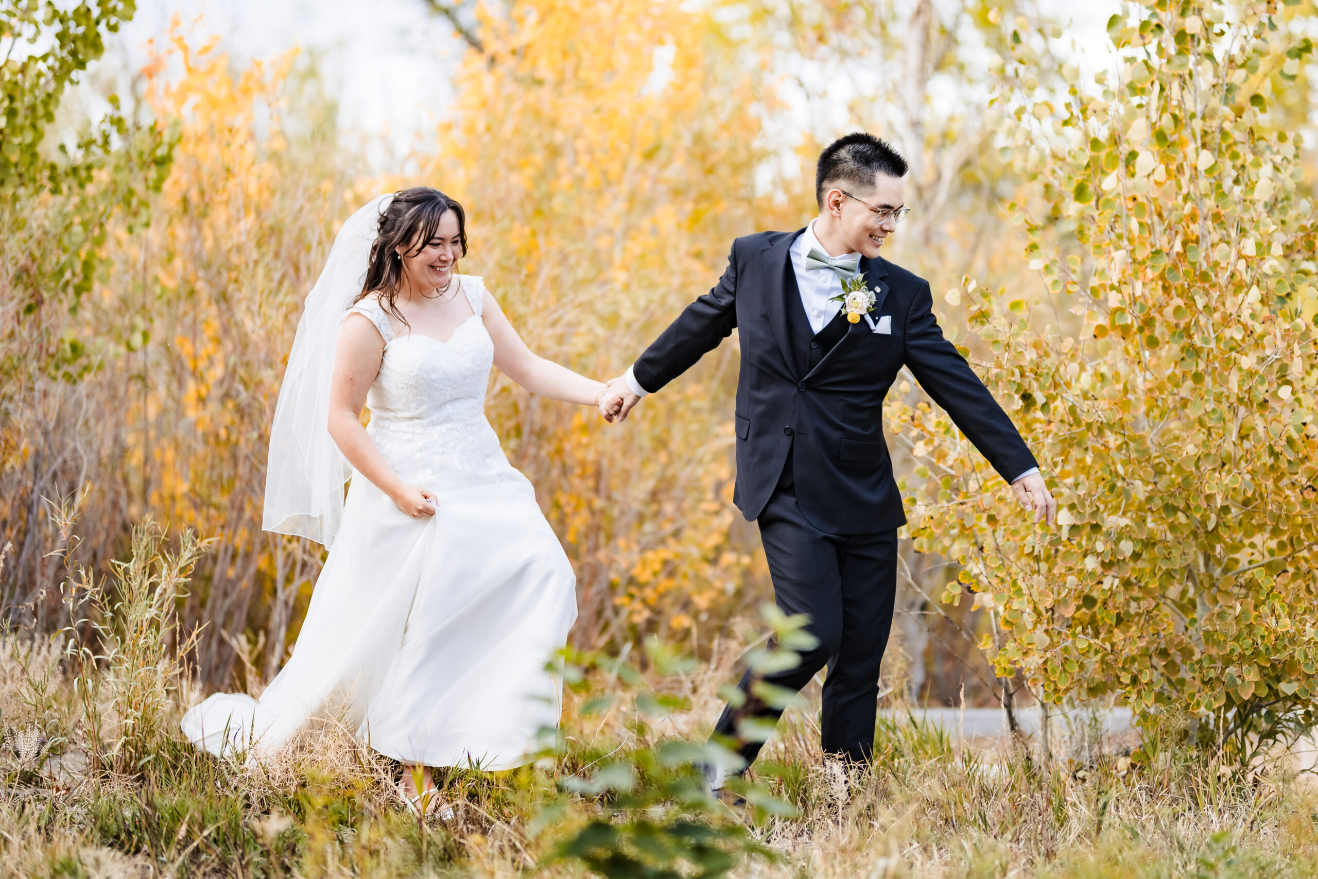 Bride and Groom walking through golden brush