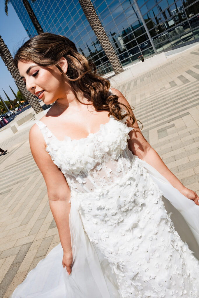 Close up bridal portrait at Christ Cathedral Garden Grove featuring a bride in a 3D floral lace wedding dress against modern glass architecture.