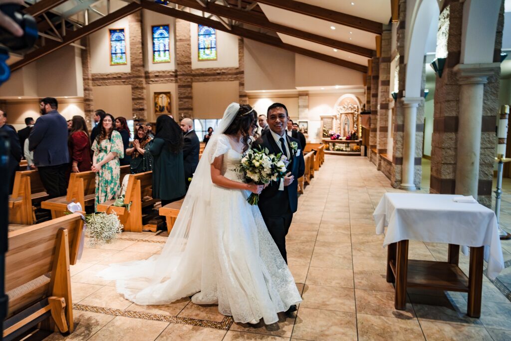 Husband and wife exiting wedding mass at St Martha's Catholic Parish in Murrieta Ca